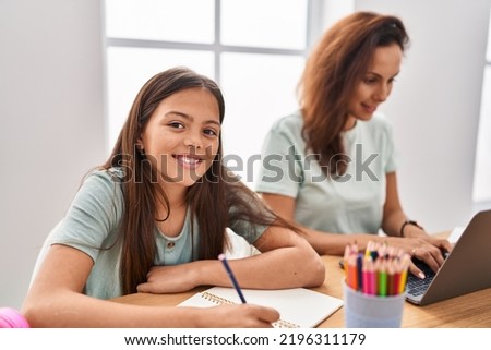 Woman and girl mother and daughter teleworking and drawing at home