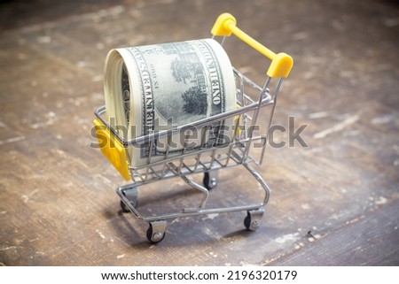 Dollar bills in a basket with wheels. Inflation in Ukraine due to war