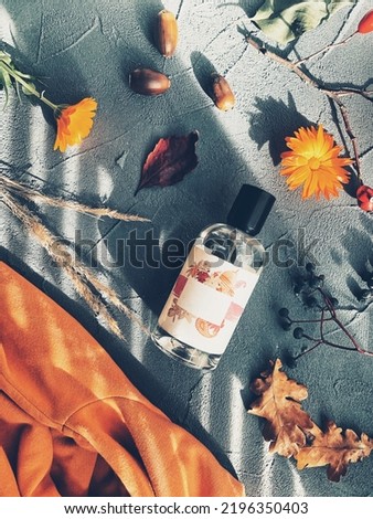 Autumn composition. Autumn concept. Flat lay, top view. Sweater, notebook, oak leaves, orange flowers, perfume, acorns, Dog Rose branch, and dry branches. Cozy autumn concept. Hygge concept
