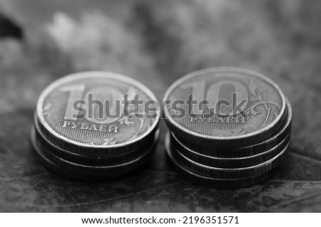 A stack of coins on the background of autumn leaves.