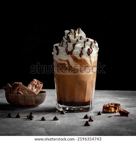 Chocolate milkshake with whipped cream with pieces of chocolate, grey and black background   Royalty-Free Stock Photo #2196354743