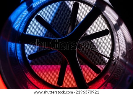abstract photo of a ventilation pipe with a fan. Blue and red creative backlight. Another look at the flour sifter.