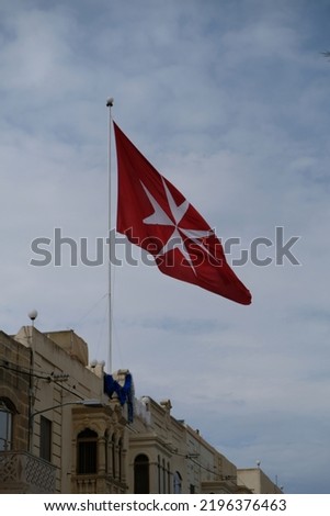 Large flag of Malta above a government building on the island of Gozo, Malta