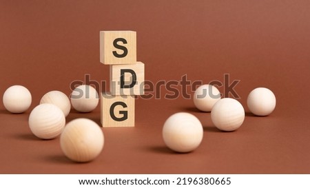 pyramid of wooden cubes with the abbreviation sdg, wooden balls on a brown background