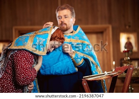 a woman repents of her sins, confessions with a priest in an Orthodox church. Royalty-Free Stock Photo #2196387047