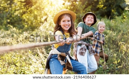 group of cheerful children play outdoors, tug of war in the summer outdoors Royalty-Free Stock Photo #2196408627