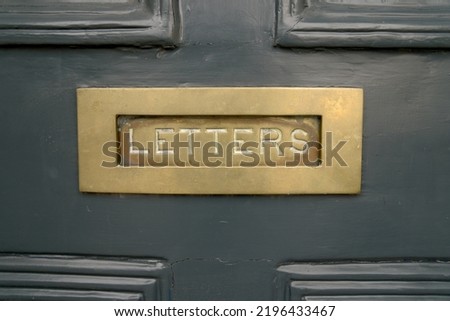 Painted solid dark green entrance door metal brass gold letter slot ornament inscription letters as a concept for postage mailings and old doors