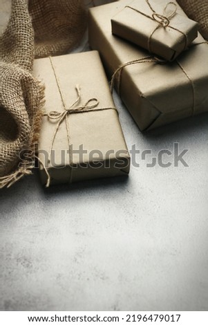 Gift box wrapped in brown recycled paper placed on a white table