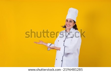 Hispanic woman chef pointing blank copy space on yellow background in Mexico latin America