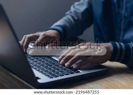 Hand of businessman working with computer laptop on desk in home office. Searching Browsing Internet Data Information with blank search bar. Search Engine Optimization SEO Networking Concept.