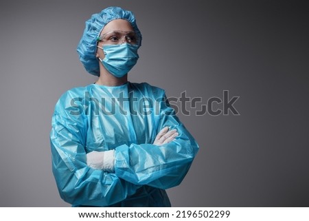 Shot of surgeon woman with crossed arms dressed in modern surgical uniform against grey background. Royalty-Free Stock Photo #2196502299