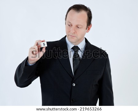 Portrait of a businessman, mature, bald, wearing a suit and tie, holding a cube with a dollar sign on white background