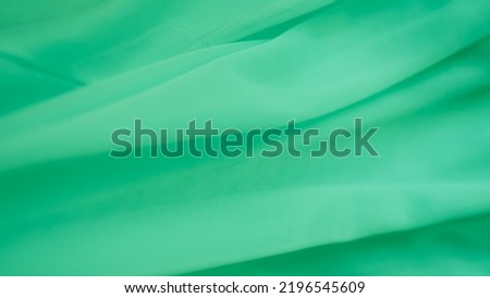 Green Color Cloth Pattern Background,Silk Wave Texture Design Backdrop,Card Poster or Banner,Light Gradient Fabric Smooth Shape Colorful,Abstract Luxury green Template Wallpaper,free space tot view. 