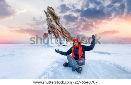 Happy Man tourist adventure landscape background blue ice cave and grotto winter from lake Baikal Russia sunset.