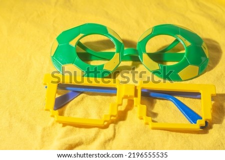 Glasses with Brazil colors, yellow and blue green, world cup concept with yellow background.