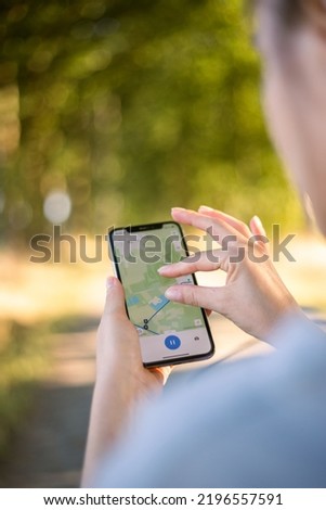 girl cyclist looks at a map on her phone and plots a route for a trip for a GPS navigator. High quality photo