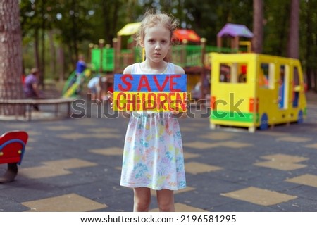 Little Ukrainian girl asks to save Ukrainian children from the war. In her hands board save children