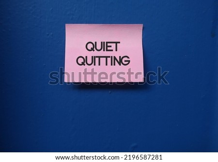 Pink note stick on blue copy space background with text QUIET QUITTING - concept of doing only what job demands and nothing more, not taking corporate job too seriously Royalty-Free Stock Photo #2196587281