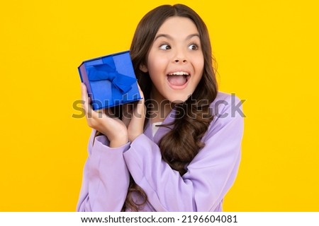 Teenager child with gift box. Present for holidays. Happy birthday, Valentines day, New Year or Christmas. Kid hold present box. Happy teenage girl, positive and smiling emotions.