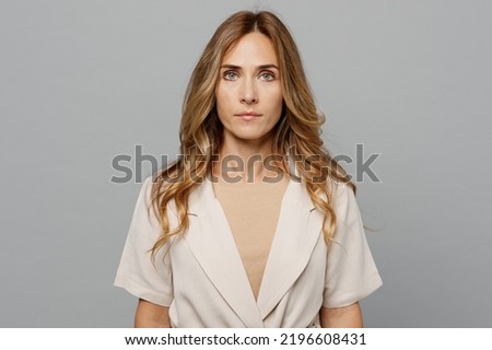 Young successful serious confident businesswoman caucasian woman 30s she wearing pastel clothes looking camera isolated on plain grey color background studio portrait. People profession career concept Royalty-Free Stock Photo #2196608431