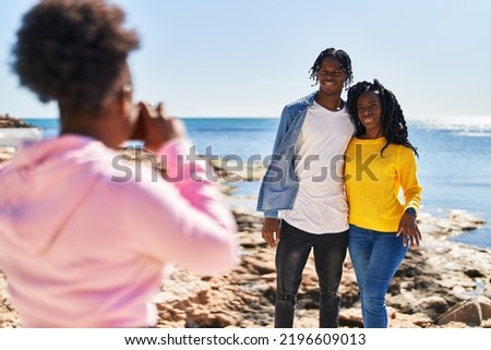 African american friends hugging each other making photo at seaside