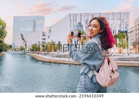 Tourist girl taking photo pictures on smartphone of a modern architecture building in Dusseldorf. Travel blogger and display quality concept