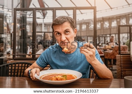 dissatisfied unhappy customer of the restaurant sniffs the disgusting smell of a bowl of soup with spoiled ingredients and is going to complain to the chef Royalty-Free Stock Photo #2196613337