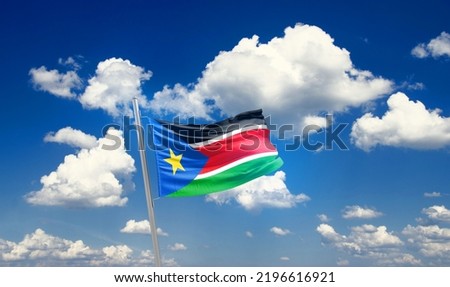 South Sudan national flag waving in beautiful clouds.