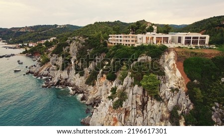 Kassandra Cliffs and a white building seen from bird's eye perspective from the direction of the sea. Cloudy sky. High quality photo