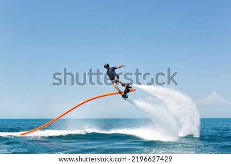 Water extreme sport. The guy is flying at the aquatic flyboard. A lot of water pressure Royalty-Free Stock Photo #2196627429
