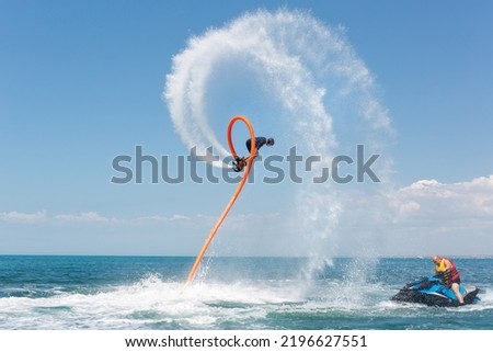 Water extreme sport. A man flies on a water flyboard