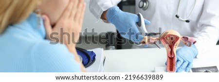 Doctor climbing fallopian tube with scissors onto artificial models on uterus and ovaries in clinic. Infertility obstruction of fallopian tubes concept Royalty-Free Stock Photo #2196639889