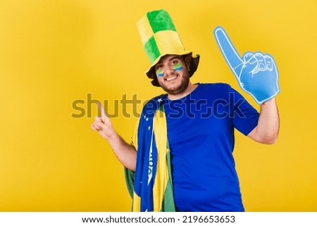 brazilian caucasian man, soccer fan from brazil, wearing hat and foam finger, dancing, doing celebratory choreography.