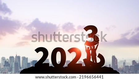 2023 New Year concept. Couple holding up an era.