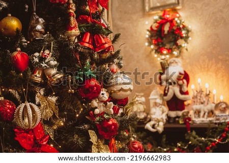 Christmas tree with toys on the background of the fireplace in the home interior.