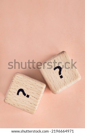 Two wooden cubes with question mark on beige background