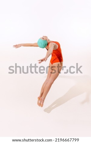 Portrait of young woman in swimming suit and cap jumping into water isolated over grey studio background. Pool diving. Concept of beauty, fashion, vintage style, summertime, party. Copy space for ad Royalty-Free Stock Photo #2196667799