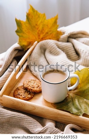 Autumn and winter home still life: a cup of coffee, cookies and yellow leaves. Seasonal breakfast, morning coffee. The concept of home comfort and a relaxed atmosphere. Royalty-Free Stock Photo #2196669353