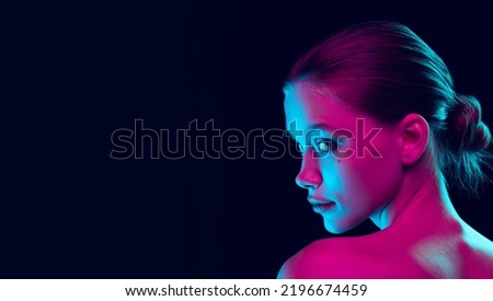 Fashion, style. Young beautiful girl with well-kept skin and without makeup isolated over dark background in neon light. Concept of natural beauty, art, emotions, cosmetics and youth. Flyer for ad Royalty-Free Stock Photo #2196674459