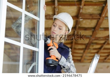 woman unscrews fastening screws handle window Royalty-Free Stock Photo #2196678475