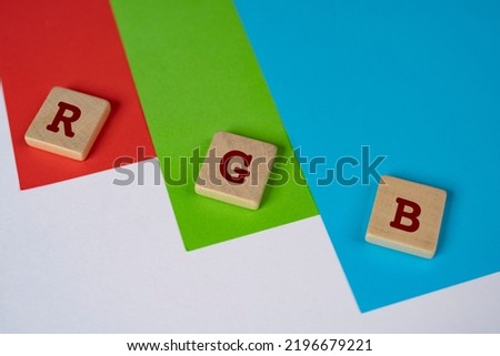 RGB color space. The letters R G and B on a wooden towels on a red, green and blue background