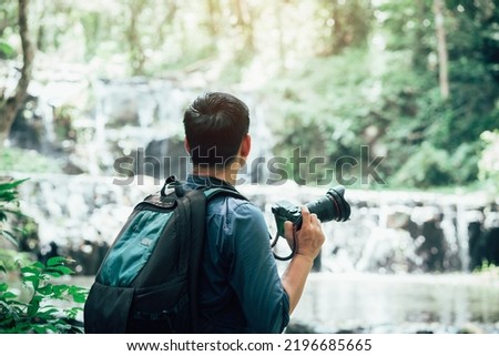 Professional photographers capture the beauty of nature with photographic equipment at a tropical waterfall.Concept of Photography
