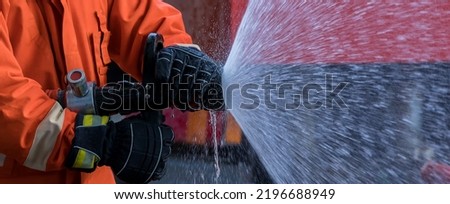 Hand spray water from hose for fire fighting. Firefighter spraying a straight steam	