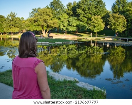Brunette standing by the reflective waters of Sar Ko Par Park in Lenexa Kansas Royalty-Free Stock Photo #2196697797