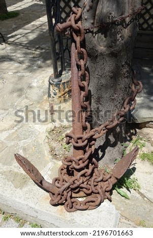 The rusty metal boat anchor