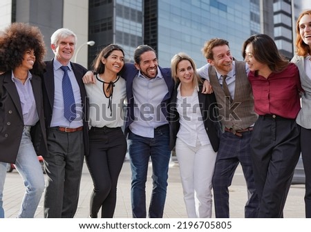 Group of multi generational business people hugging each other outside of office building Royalty-Free Stock Photo #2196705805