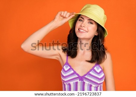 Photo of beauty brunette lady hand cap wear top isolated on orange color background