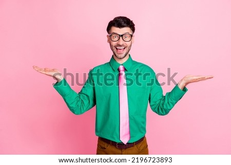 Closeup photo of young handsome guy smiling surprised with prices holding hands choosing best deal isolated on pink color background