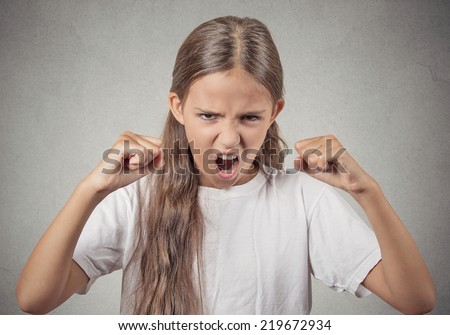 Closeup Portrait Angry child, teenager girl Screaming fists up, demanding justice isolated grey wall background. Negative human Emotions, Facial Expressions, body language, bad attitude, perception