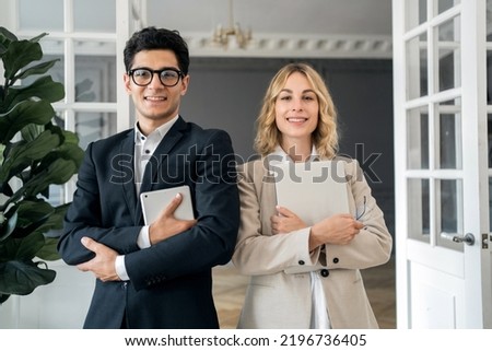 Managers and partners in formal attire work in the office, a woman uses a tablet in her hands
